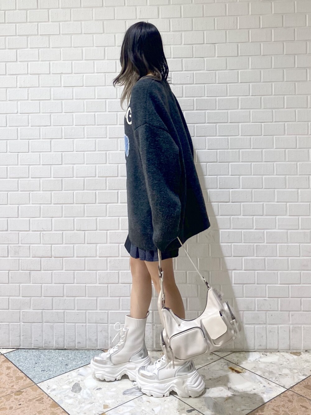 ホワイト系のブーツ、ホワイト系のショルダーバッグ、ブラック系のその他パンツを着用したレディースの秋コーディネートの5枚目の写真