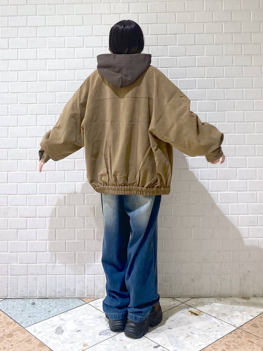 ブラウン系のブーツ、ブルー系のデニムパンツ、ブラウン系のパーカーを着用したレディースの秋コーディネートの7枚目の写真