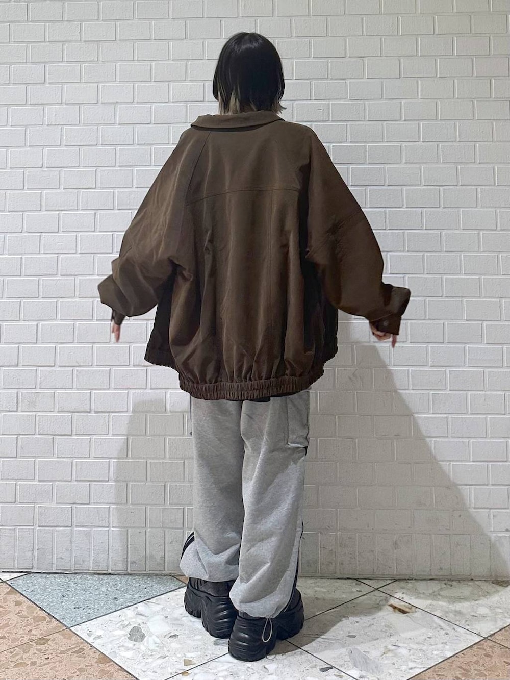 ブラック系のスニーカー、ブラウン系のブルゾン、ブラウン系のニット/セーターを着用したレディースの冬コーディネートの6枚目の写真