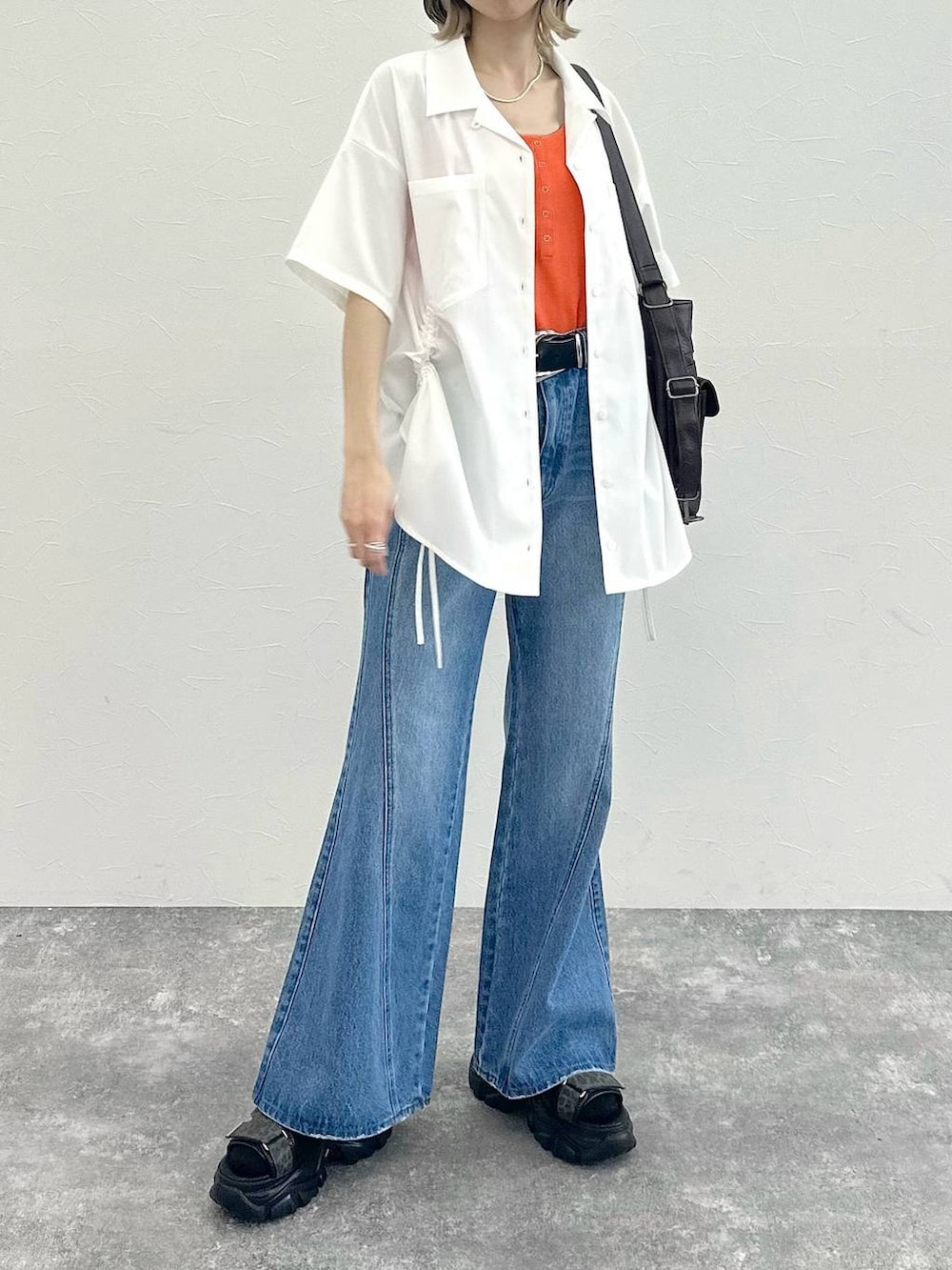 ブルー系のデニムパンツ、ブラック系のショルダーバッグ、グレー系のサンダルを着用したレディースの春コーディネートの2枚目の写真