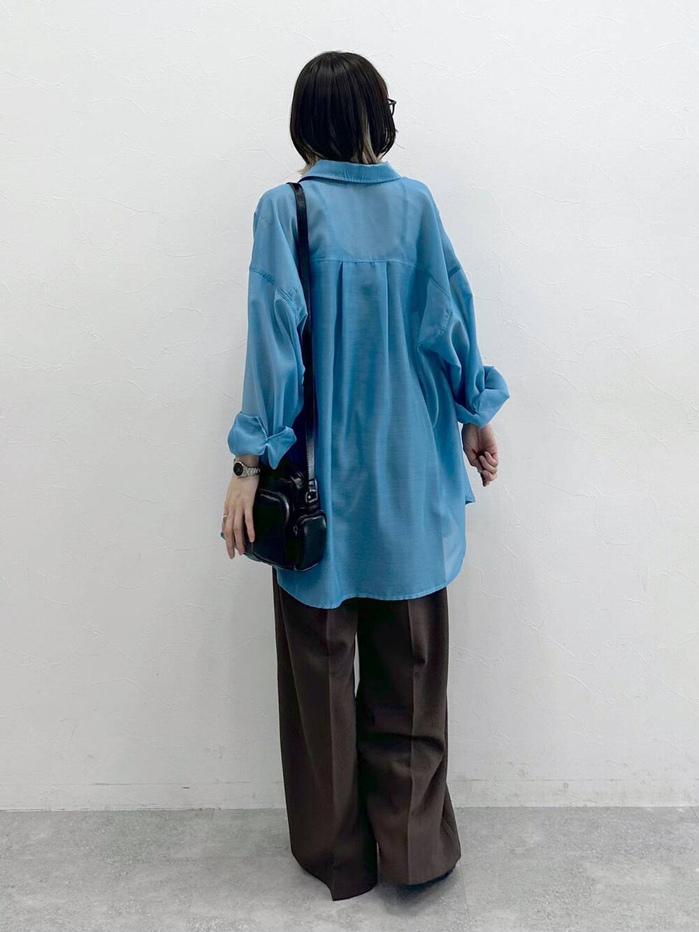 ブラック系のキャミソール、ブラック系のスニーカー、ブラック系のショルダーバッグを着用したレディースの春コーディネートの6枚目の写真