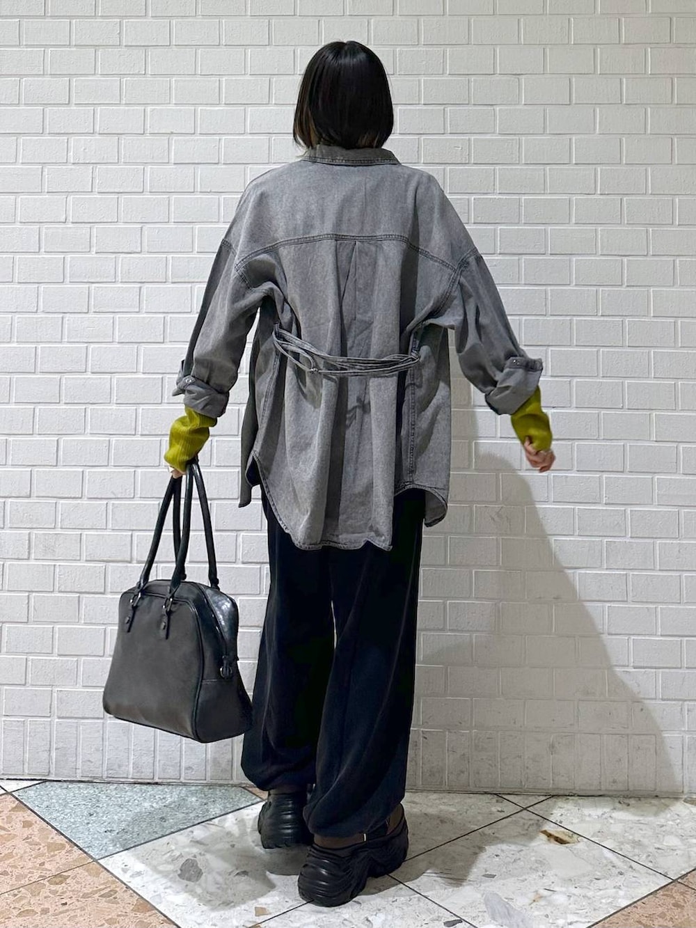 ブラウン系のブーツ、ブラック系のボストンバッグ、ブラック系のシャツ/ブラウスを着用したレディースの冬コーディネートの5枚目の写真