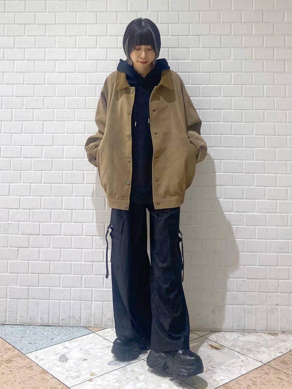 ブラック系のブーツ、ブラック系のパーカー、ベージュ系のブルゾンを着用したレディースの秋コーディネートの3枚目の写真