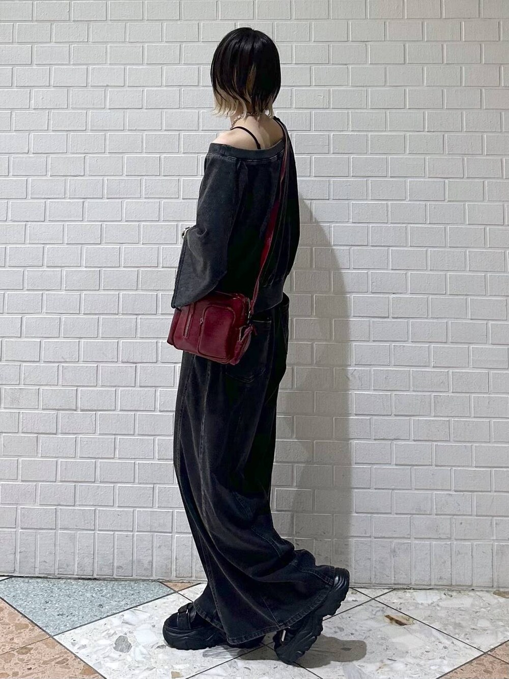 ブラック系のデニムパンツ、ブラック系のTシャツ/カットソー、レッド系のショルダーバッグを着用したレディースの夏コーディネートの5枚目の写真