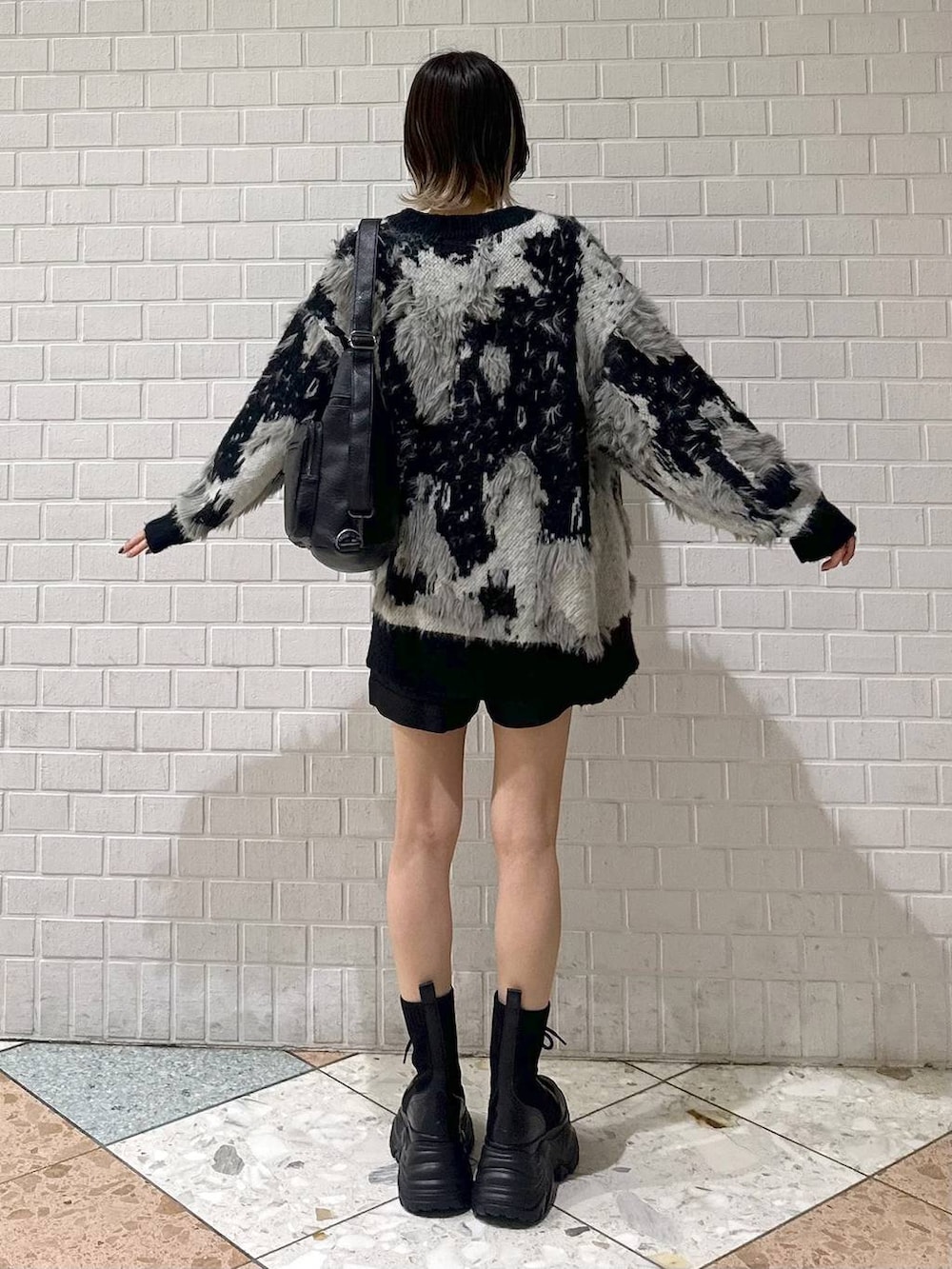ブラック系のブーツ、ホワイト系のカーディガン/ボレロ、ブラック系のその他パンツを着用したレディースの夏コーディネートの5枚目の写真