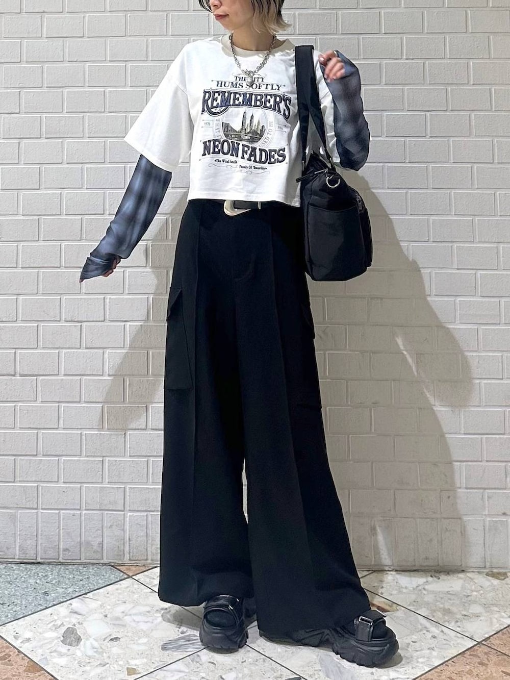 ブラック系のボストンバッグ、ブラック系のサンダル、ホワイト系のTシャツ/カットソーを着用したレディースの春コーディネートの2枚目の写真
