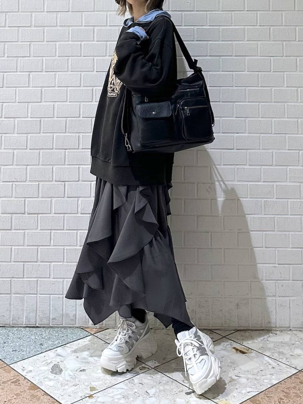 ホワイト系のスニーカー、グレー系のスカート、グレー系のスウェットを着用したレディースの冬コーディネートの4枚目の写真