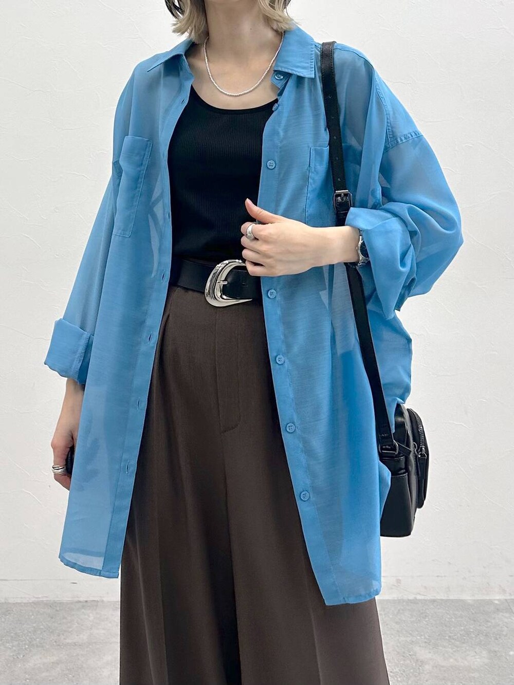 ブラック系のキャミソール、ブラック系のスニーカー、ブラック系のショルダーバッグを着用したレディースの春コーディネートの9枚目の写真