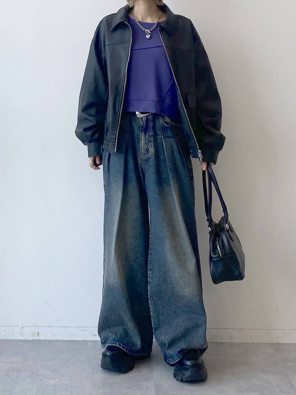 ブラック系のスニーカー、ブルー系のデニムパンツ、ブラック系のブルゾンを着用したレディースの夏コーディネートの2枚目の写真