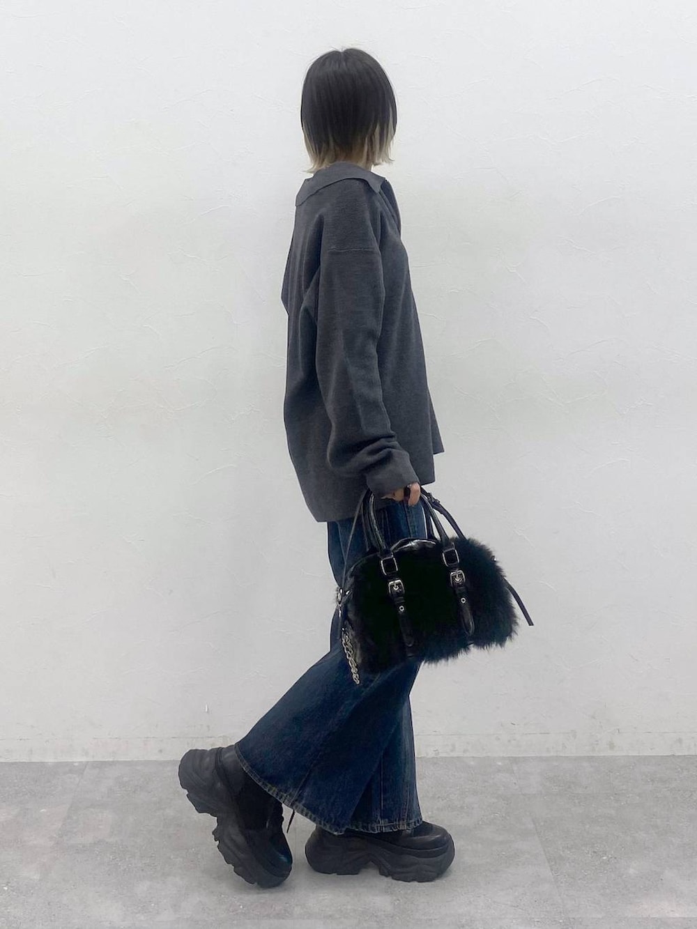 ブラック系のブーツ、ブルー系のデニムパンツ、レッド系のTシャツ/カットソーを着用したレディースの秋コーディネートの4枚目の写真