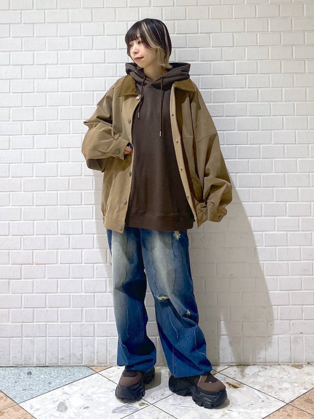 ブラウン系のブーツ、ブルー系のデニムパンツ、ブラウン系のパーカーを着用したレディースの秋コーディネートの9枚目の写真