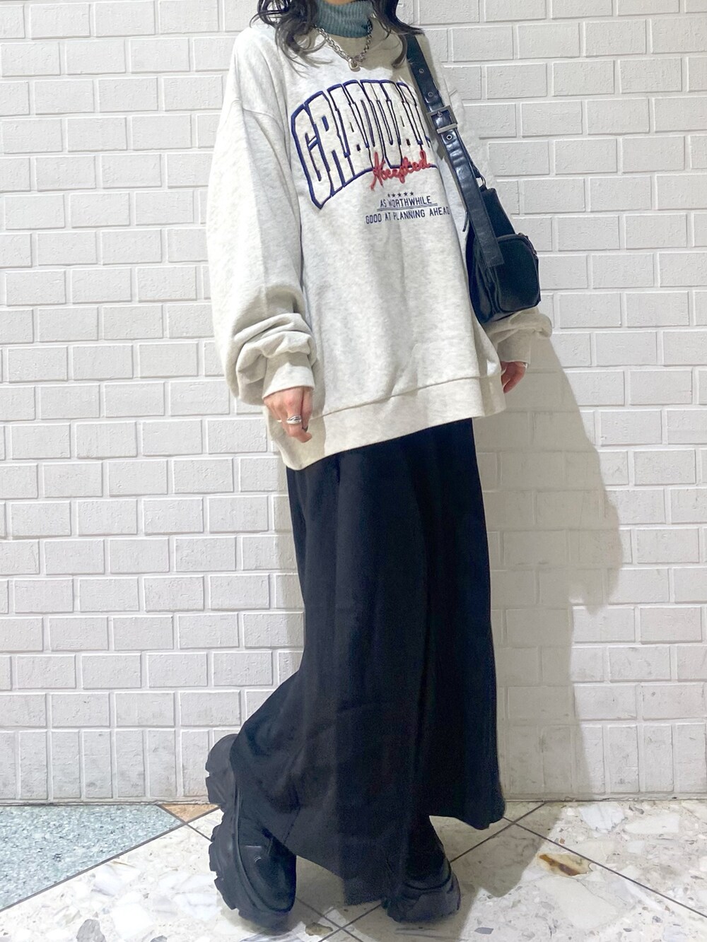 ブラック系のスニーカー、ブラック系のスカート、ベージュ系のスウェットを着用したレディースの冬コーディネートの6枚目の写真