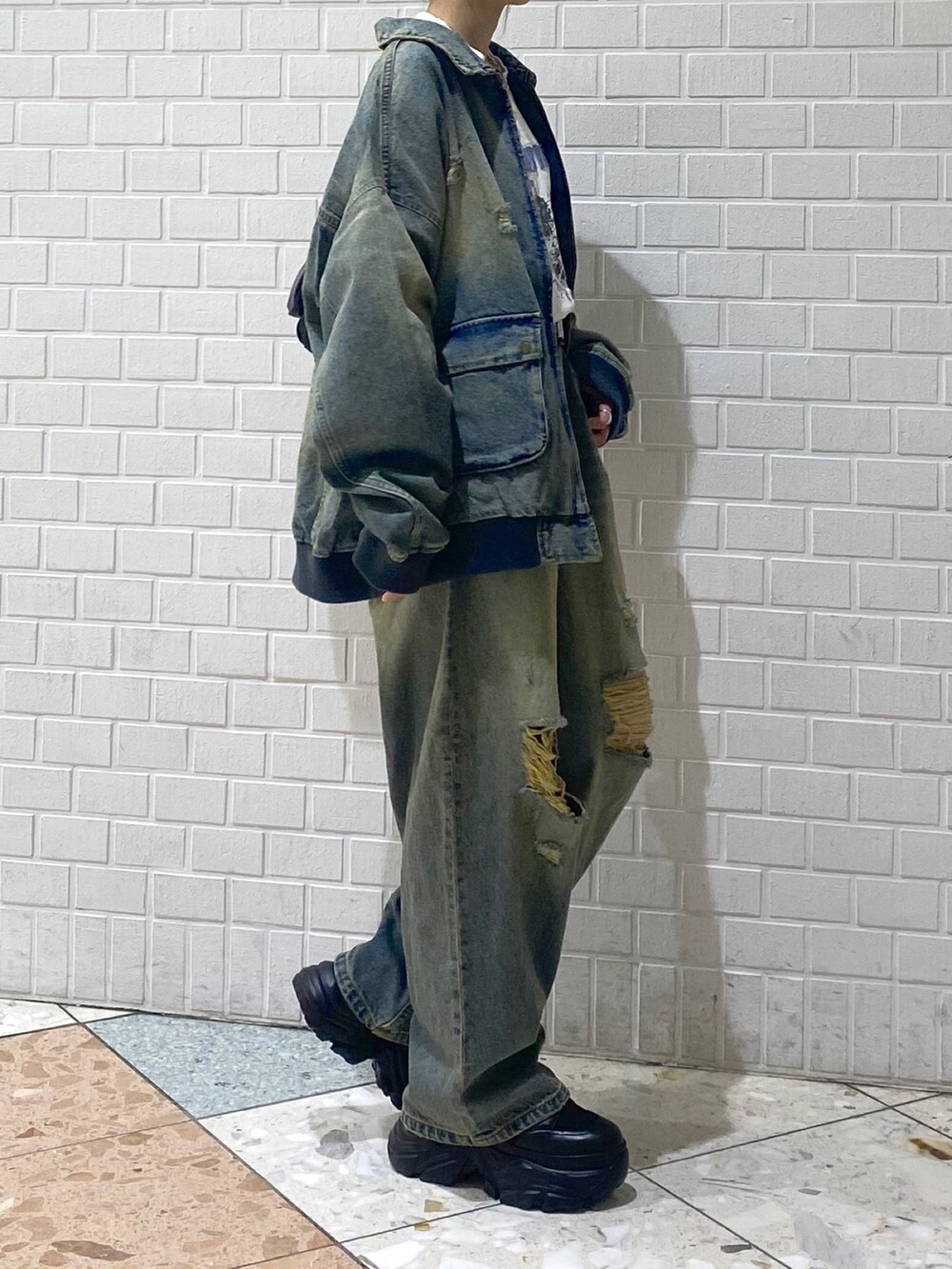 ブラック系のブーツ、ブルー系のデニムパンツ、ホワイト系のTシャツ/カットソーを着用したレディースの秋コーディネートの5枚目の写真