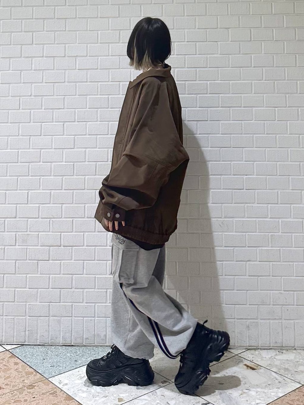 ブラック系のスニーカー、ブラウン系のブルゾン、ブラウン系のニット/セーターを着用したレディースの冬コーディネートの5枚目の写真