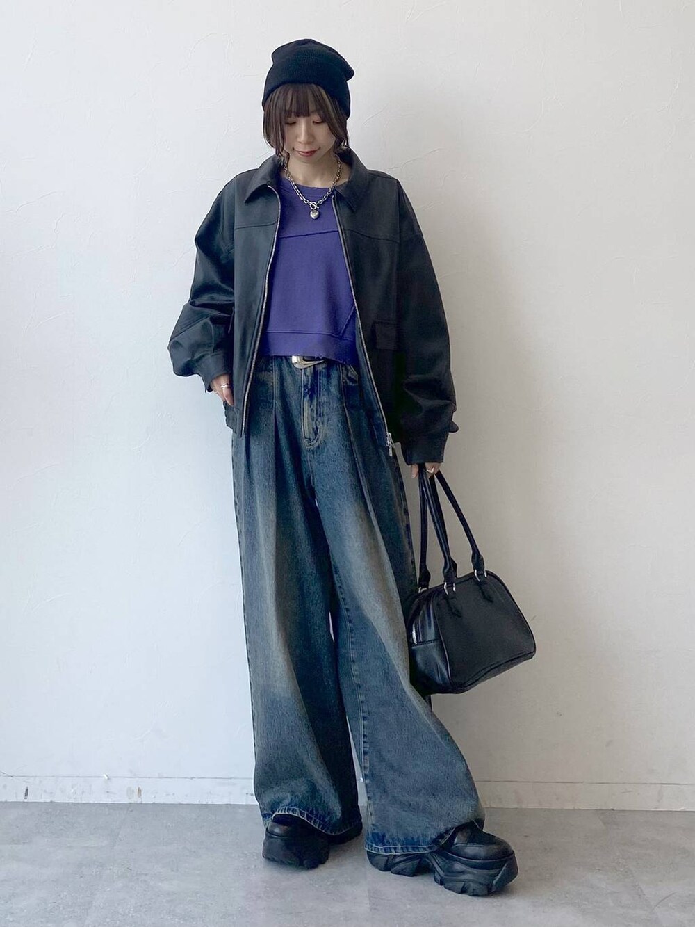 ブラック系のスニーカー、ブルー系のデニムパンツ、ブラック系のブルゾンを着用したレディースの夏コーディネートの7枚目の写真