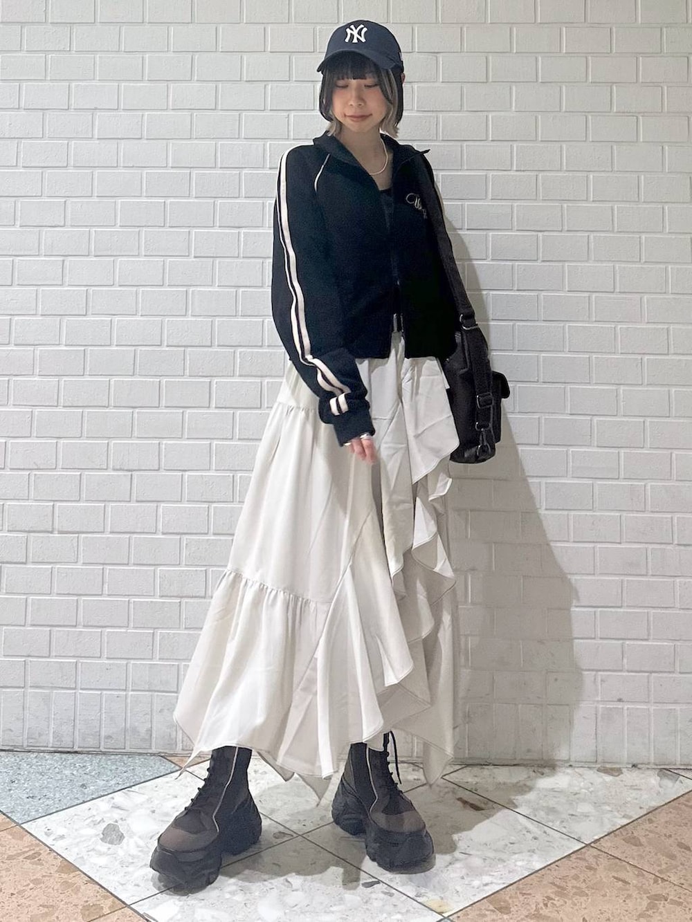 ブラウン系のブーツ、ブラック系のキャミソール、ベージュ系のスカートを着用したレディースの春コーディネートの8枚目の写真