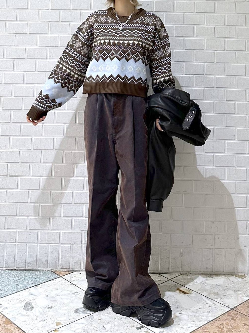 ブラック系のブーツ、ブラック系のブルゾン、ブルー系のデニムパンツを着用したレディースの冬コーディネートの7枚目の写真