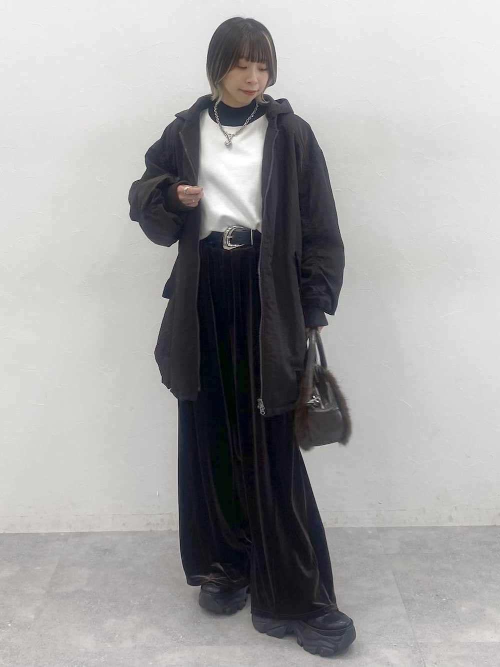 ブラック系のブーツ、ホワイト系のニット/セーター、ブラウン系のブルゾンを着用したレディースの秋コーディネートの4枚目の写真