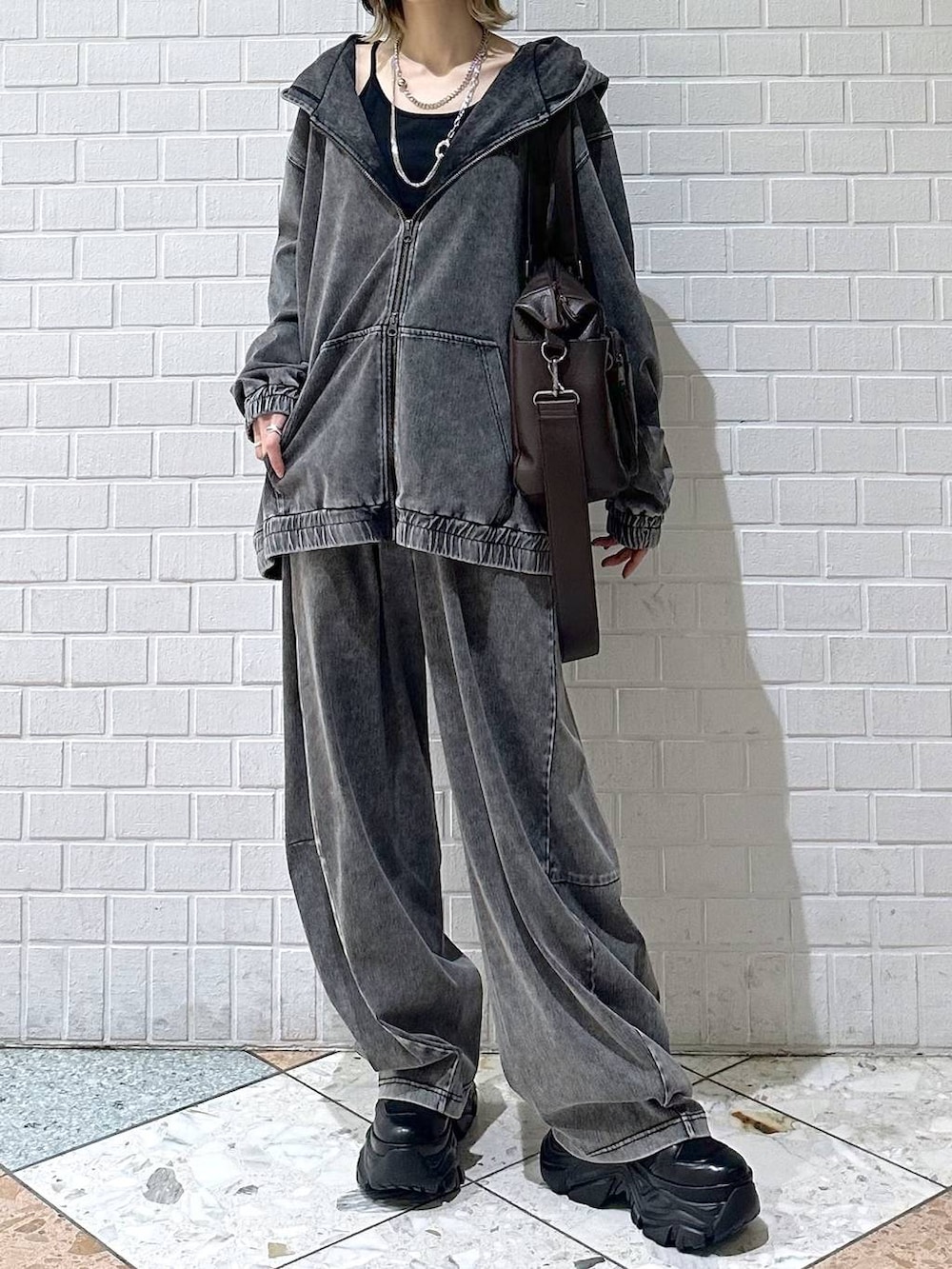 ブラック系のブーツ、ブラック系のキャミソール、ブラウン系のボストンバッグを着用したレディースの冬コーディネートの3枚目の写真