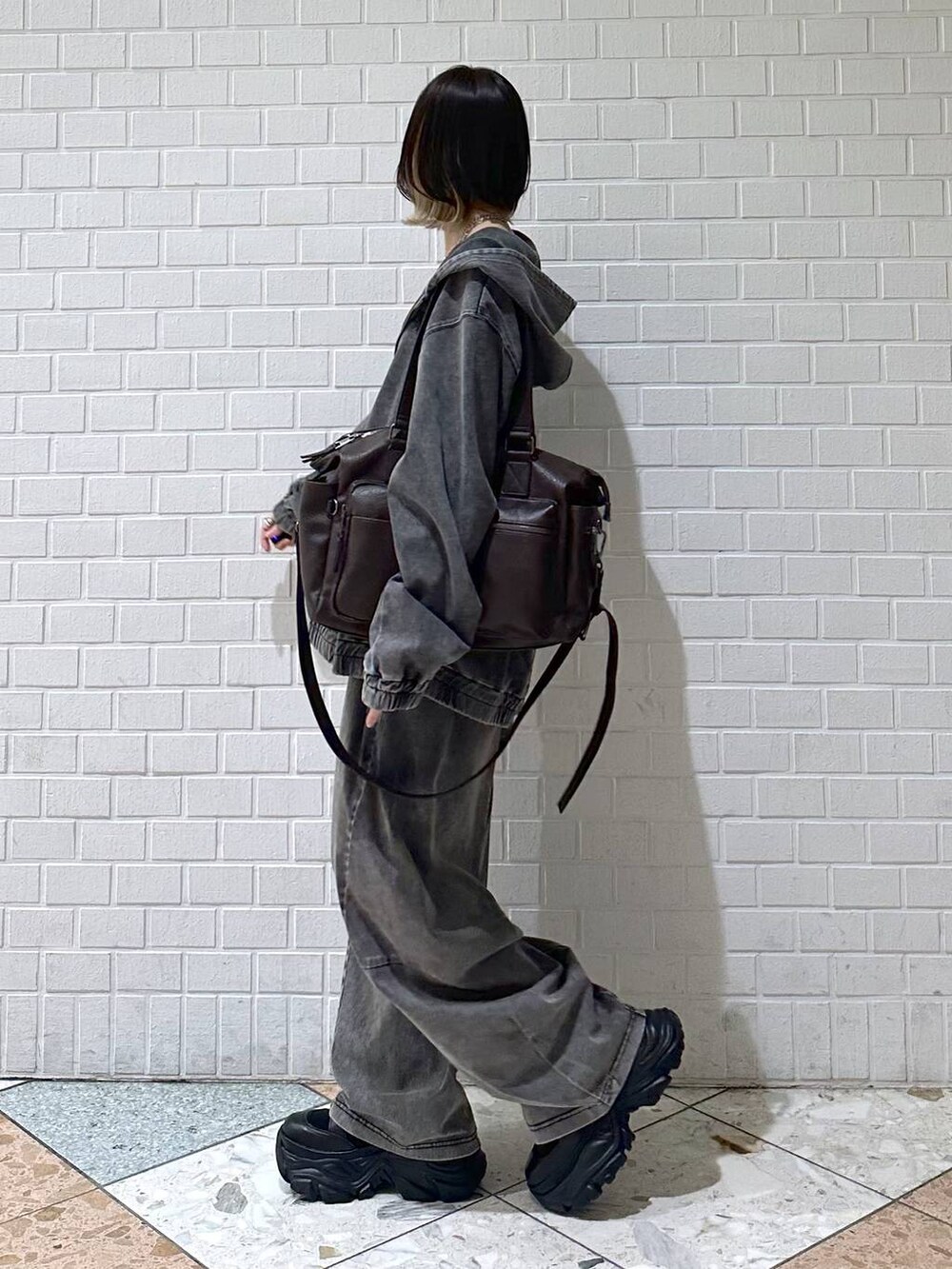 ブラック系のブーツ、ブラック系のキャミソール、ブラウン系のボストンバッグを着用したレディースの冬コーディネートの5枚目の写真