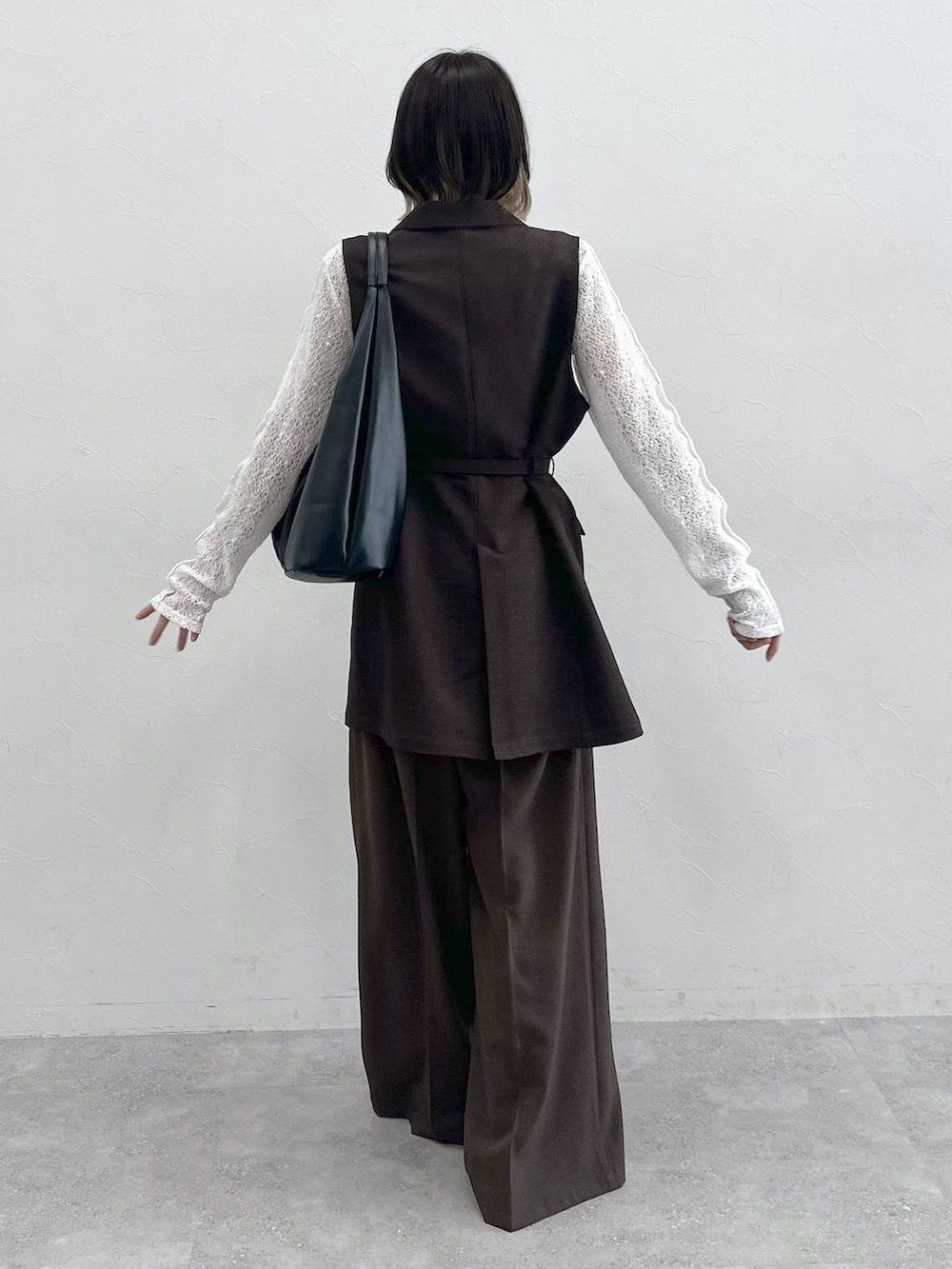ブラック系のスニーカー、ブラック系のトートバッグ、ホワイト系のTシャツ/カットソーを着用したレディースの夏コーディネートの7枚目の写真