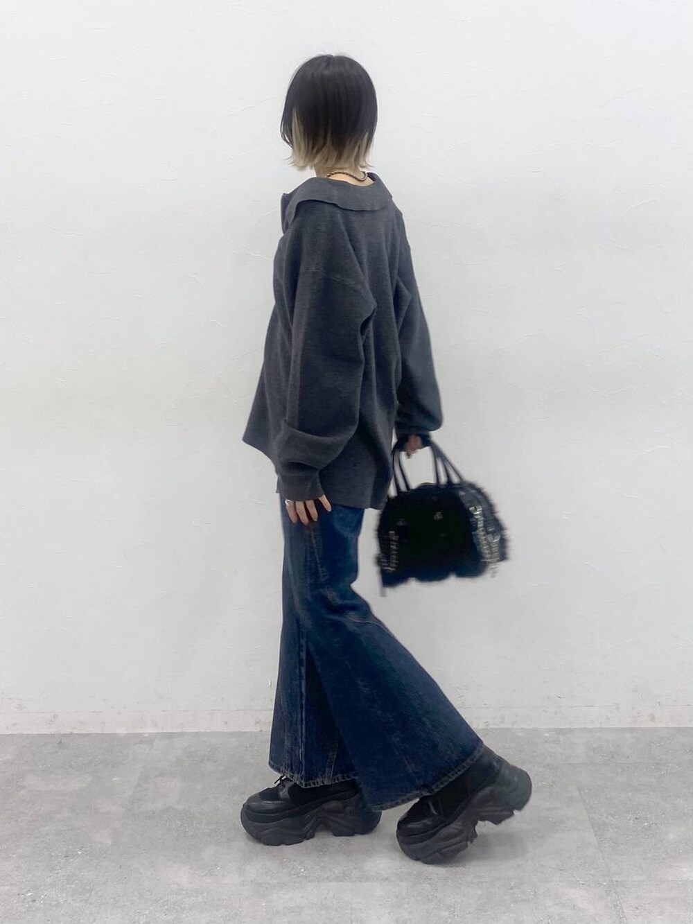 ブラック系のブーツ、ブルー系のデニムパンツ、レッド系のTシャツ/カットソーを着用したレディースの秋コーディネートの7枚目の写真