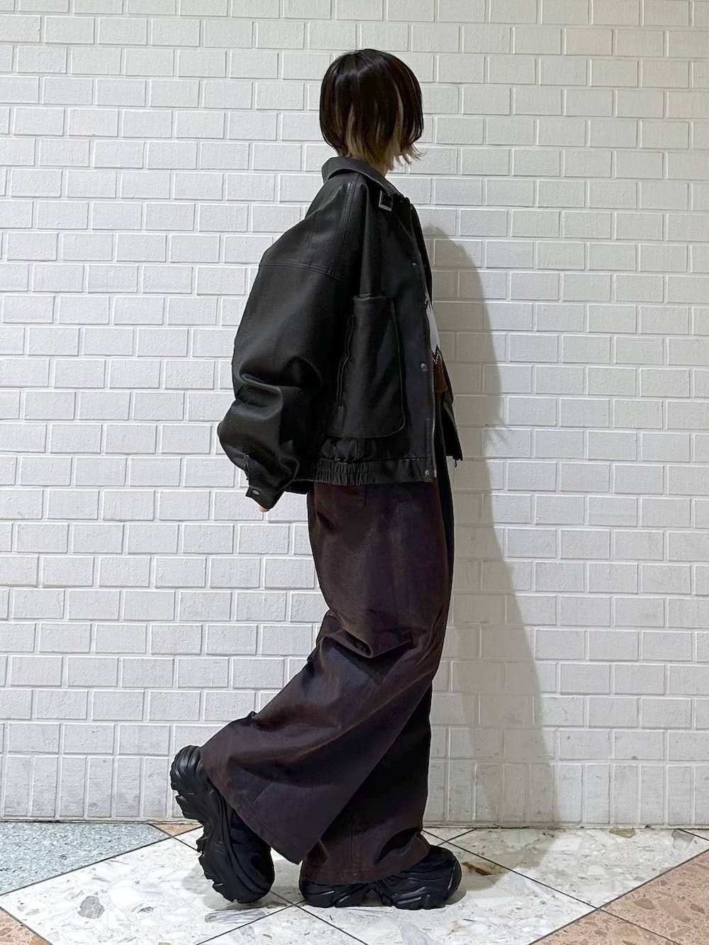 ブラック系のブーツ、ブラック系のブルゾン、ブルー系のデニムパンツを着用したレディースの冬コーディネートの6枚目の写真