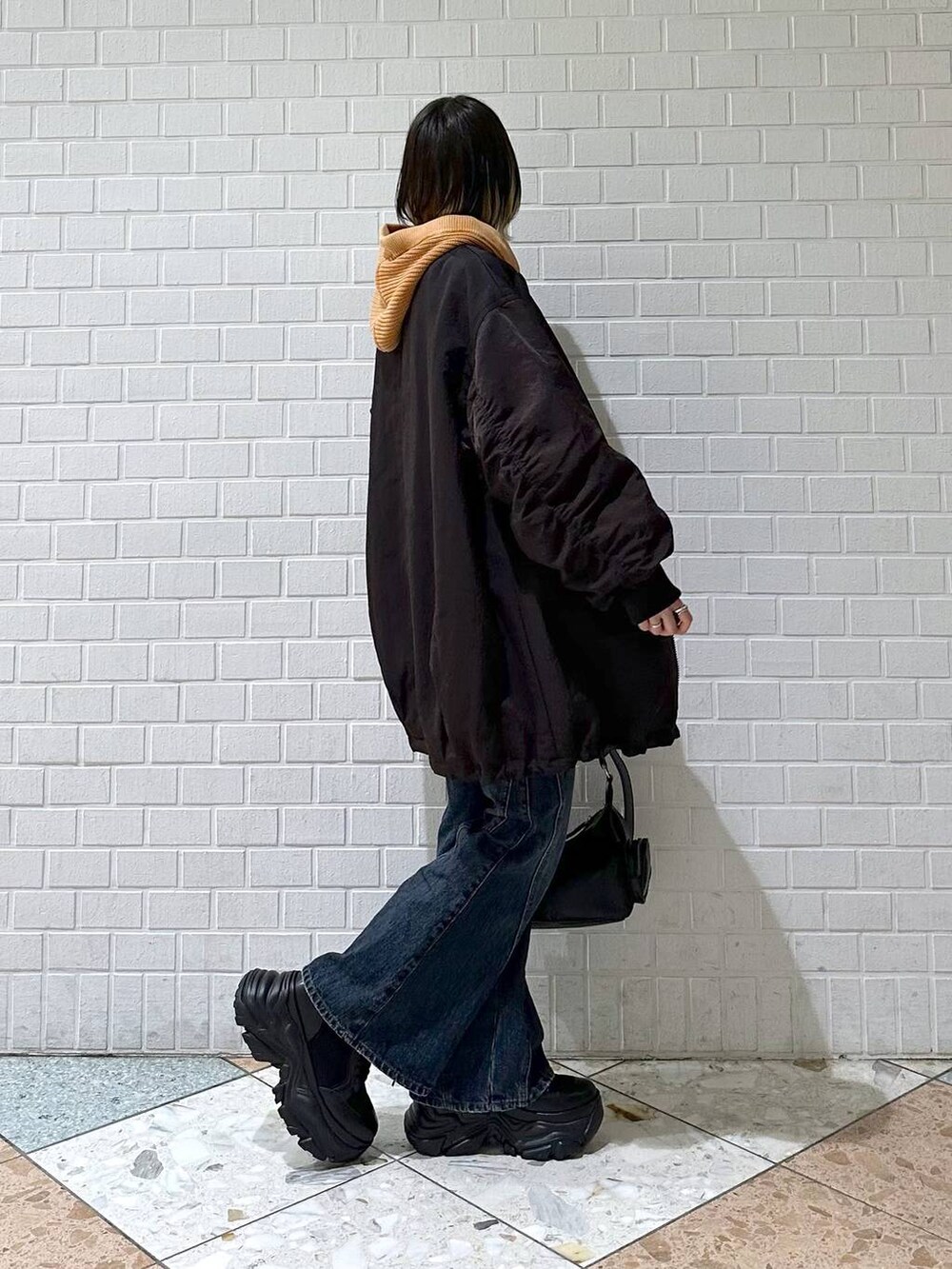 ブラック系のブーツ、ブルー系のデニムパンツ、ブラウン系のブルゾンを着用したレディースの秋コーディネートの7枚目の写真