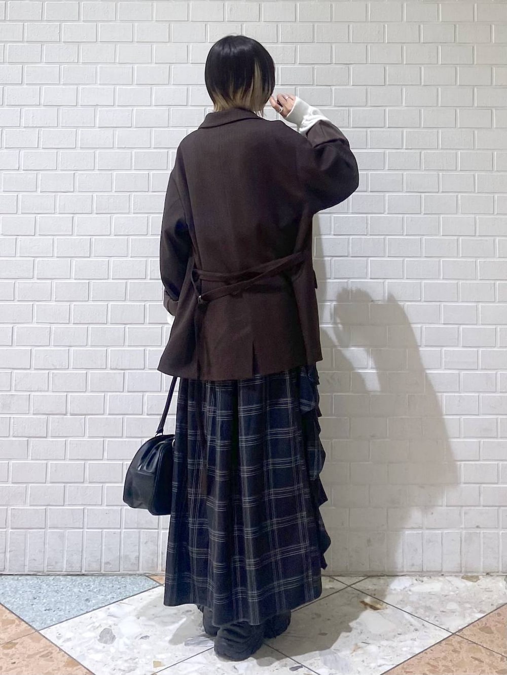 ブラウン系のブーツ、ブラック系のボストンバッグ、ホワイト系のニット/セーターを着用したレディースの秋コーディネートの6枚目の写真