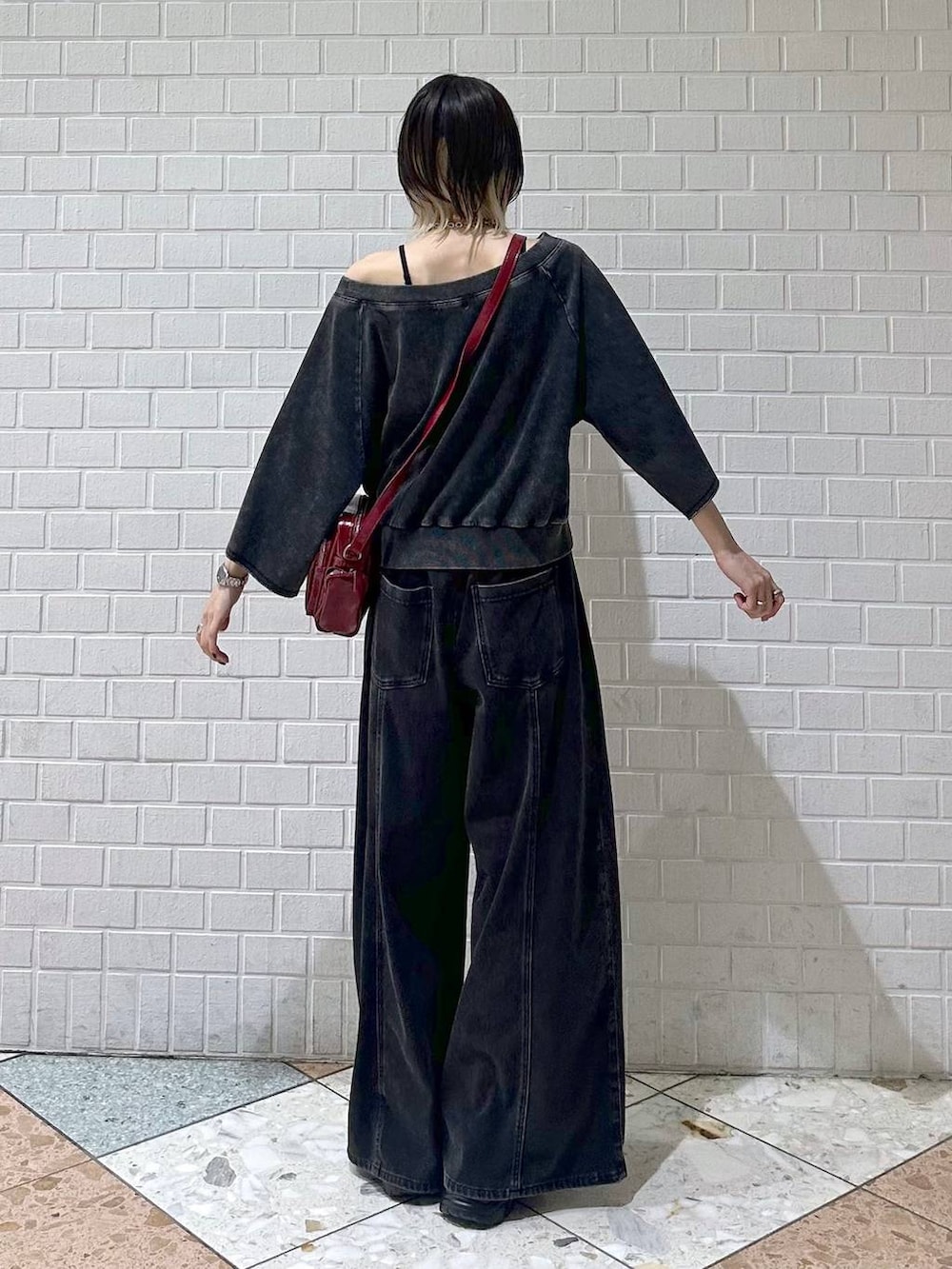 ブラック系のデニムパンツ、ブラック系のTシャツ/カットソー、レッド系のショルダーバッグを着用したレディースの夏コーディネートの6枚目の写真