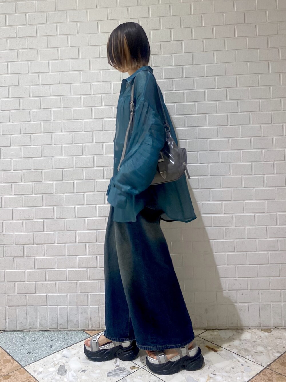 グレー系のサンダル、ブルー系のデニムパンツ、グリーン系のシャツ/ブラウスを着用したレディースの春コーディネートの3枚目の写真