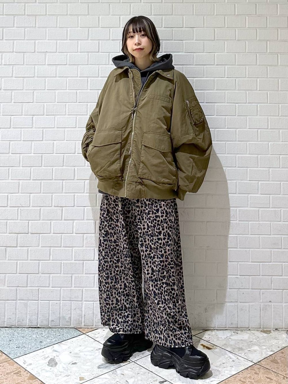 ブラック系のブーツ、グレー系のパーカー、ベージュ系のその他パンツを着用したレディースの冬コーディネートの3枚目の写真