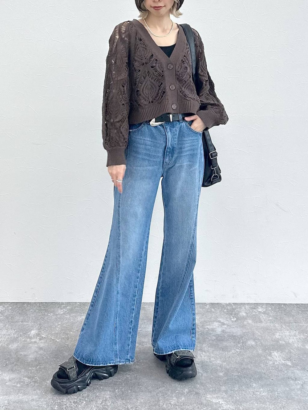 ブラック系のキャミソール、ブラウン系のカーディガン/ボレロ、ブルー系のデニムパンツを着用したレディースの春コーディネートの9枚目の写真