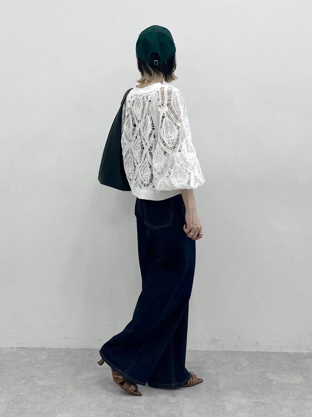 ブラック系のキャミソール、ホワイト系のカーディガン/ボレロ、ブルー系のスラックスを着用したレディースの春コーディネートの8枚目の写真