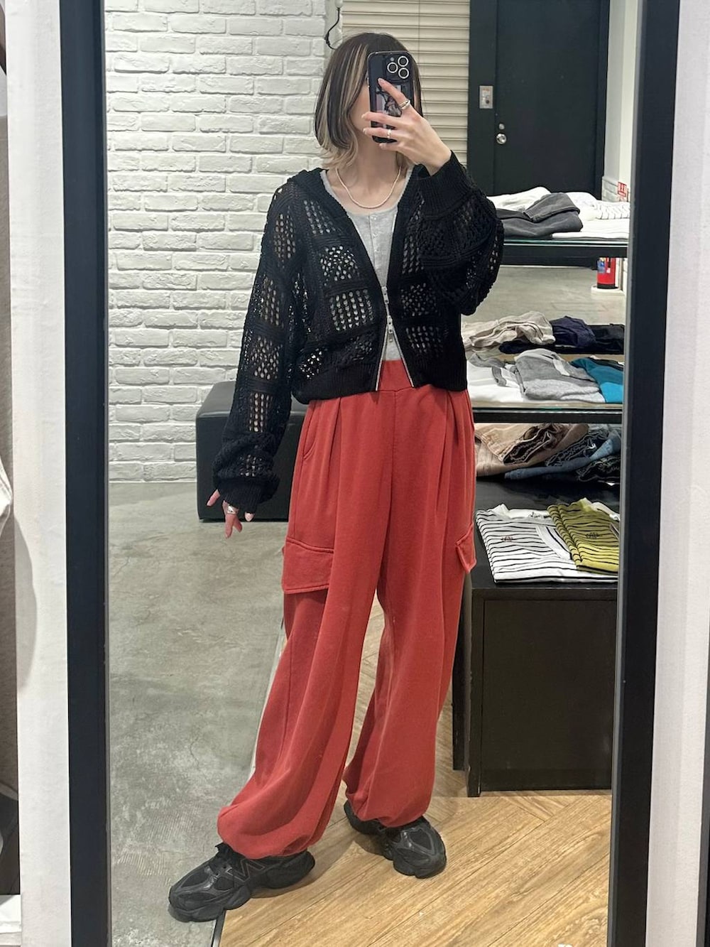 ブラック系のパーカー、グレー系のタンクトップ、レッド系のその他パンツを着用したレディースの春コーディネートの4枚目の写真