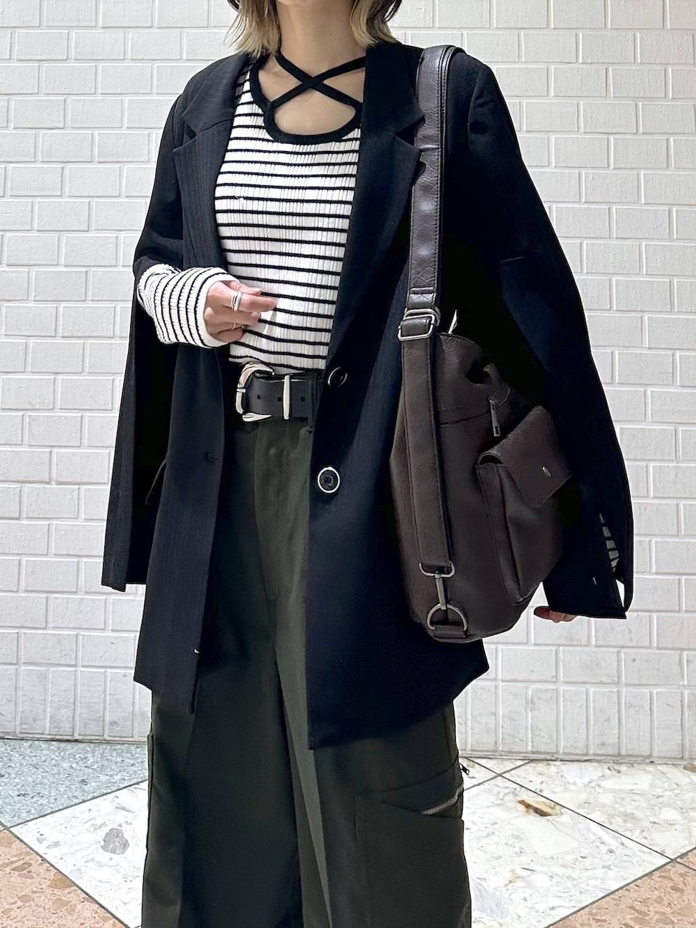 ブラック系のテーラードジャケット、ホワイト系のスニーカー、グリーン系のスラックスを着用したレディースの冬コーディネートの9枚目の写真