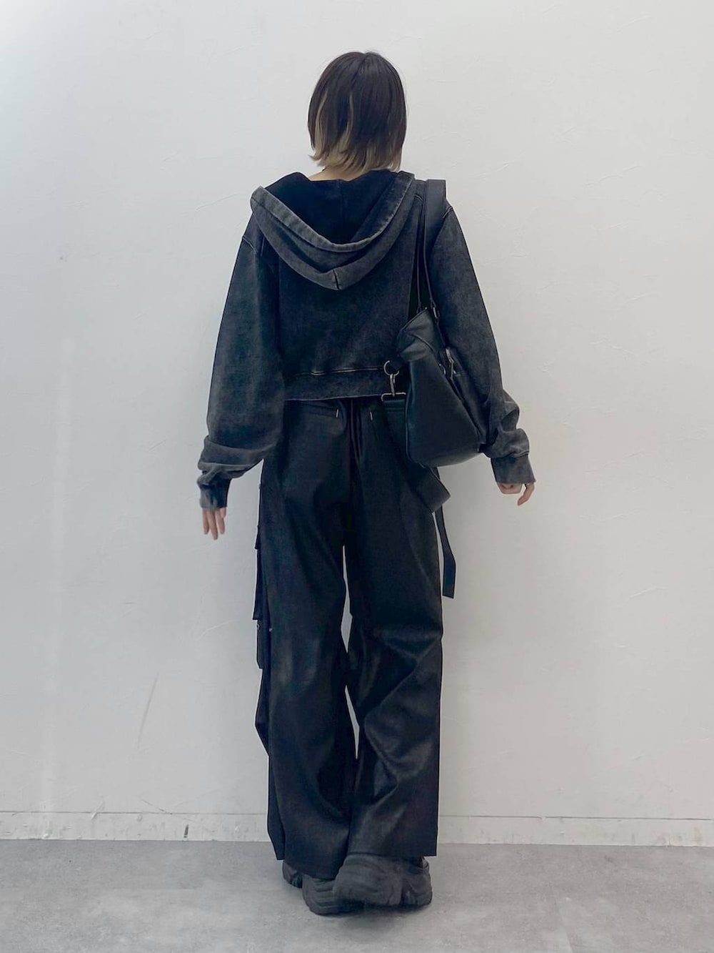 ブラック系のスニーカー、ホワイト系のキャミソール、ブラック系のカーゴパンツを着用したレディースの夏コーディネートの5枚目の写真