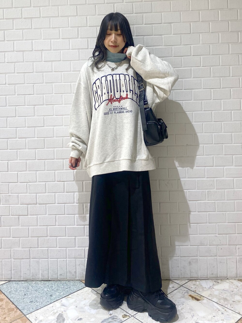 ブラック系のスニーカー、ブラック系のスカート、ベージュ系のスウェットを着用したレディースの冬コーディネートの8枚目の写真