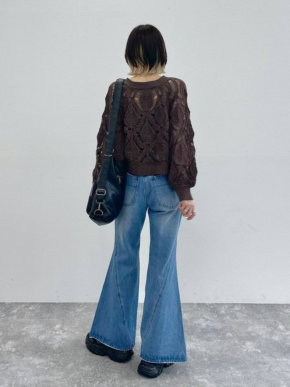 ブラック系のキャミソール、ブラウン系のカーディガン/ボレロ、ブルー系のデニムパンツを着用したレディースの春コーディネートの6枚目の写真