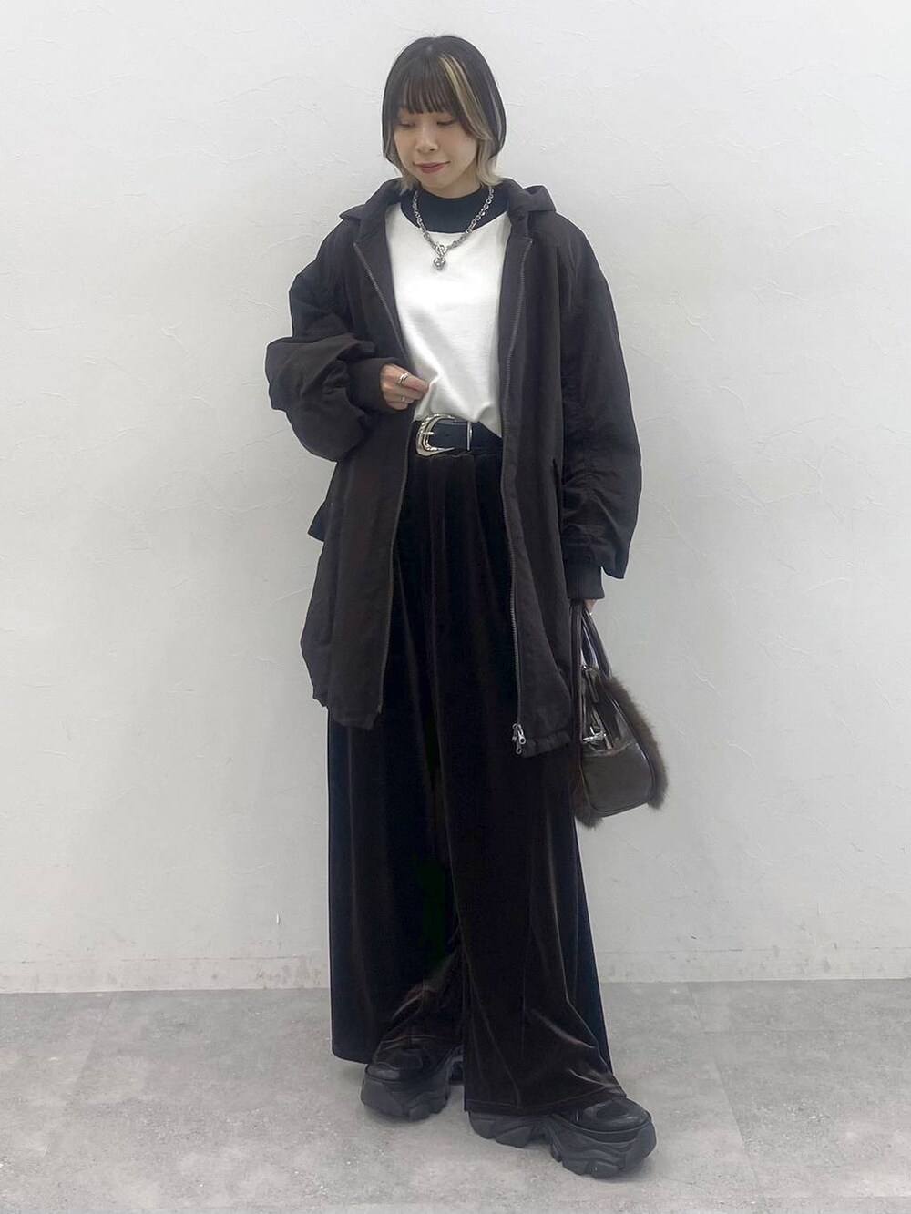 ブラック系のブーツ、ホワイト系のニット/セーター、ブラウン系のブルゾンを着用したレディースの秋コーディネートの9枚目の写真