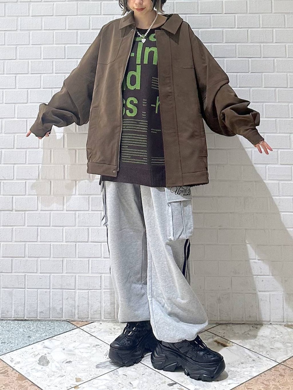 ブラック系のスニーカー、ブラウン系のブルゾン、ブラウン系のニット/セーターを着用したレディースの冬コーディネートの3枚目の写真