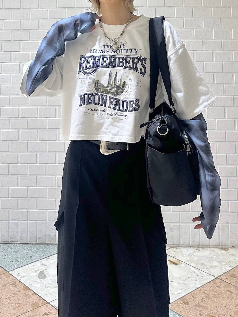 ブラック系のボストンバッグ、ブラック系のサンダル、ホワイト系のTシャツ/カットソーを着用したレディースの春コーディネートの8枚目の写真