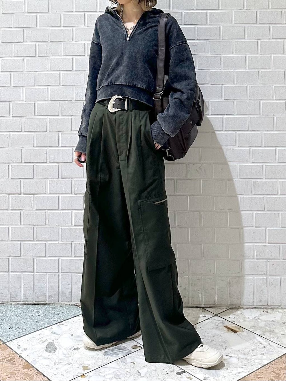 ブラック系のキャミソール、グレー系のパーカー、ホワイト系のスニーカーを着用したレディースの冬コーディネートの3枚目の写真