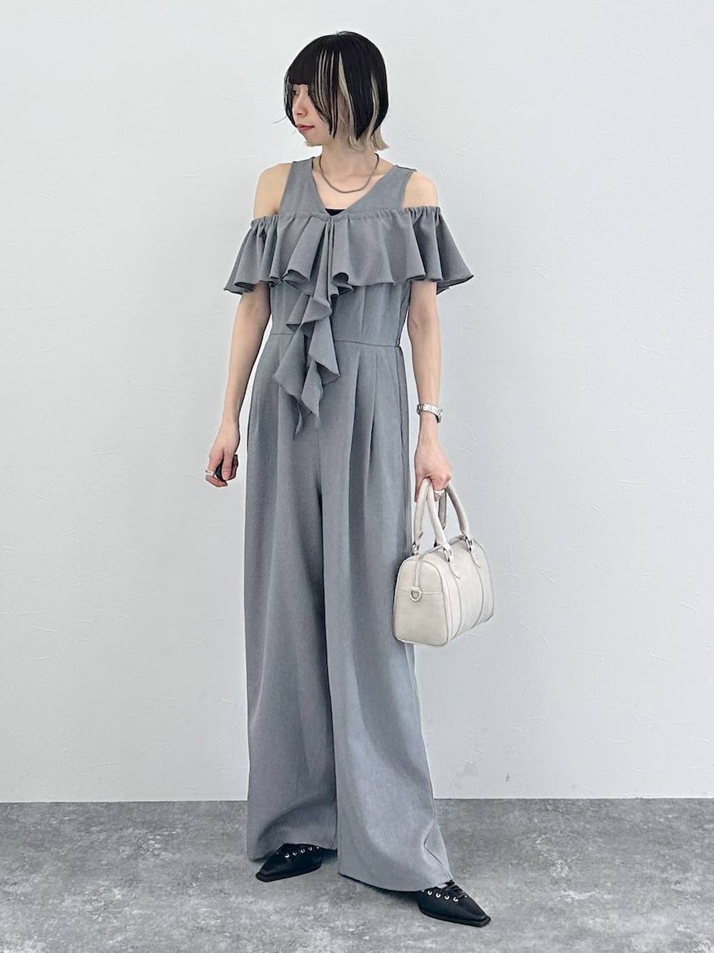 ホワイト系のボストンバッグ、ブラック系のサンダル、グレー系のサロペット/オーバーオールを着用したレディースの春コーディネートの4枚目の写真