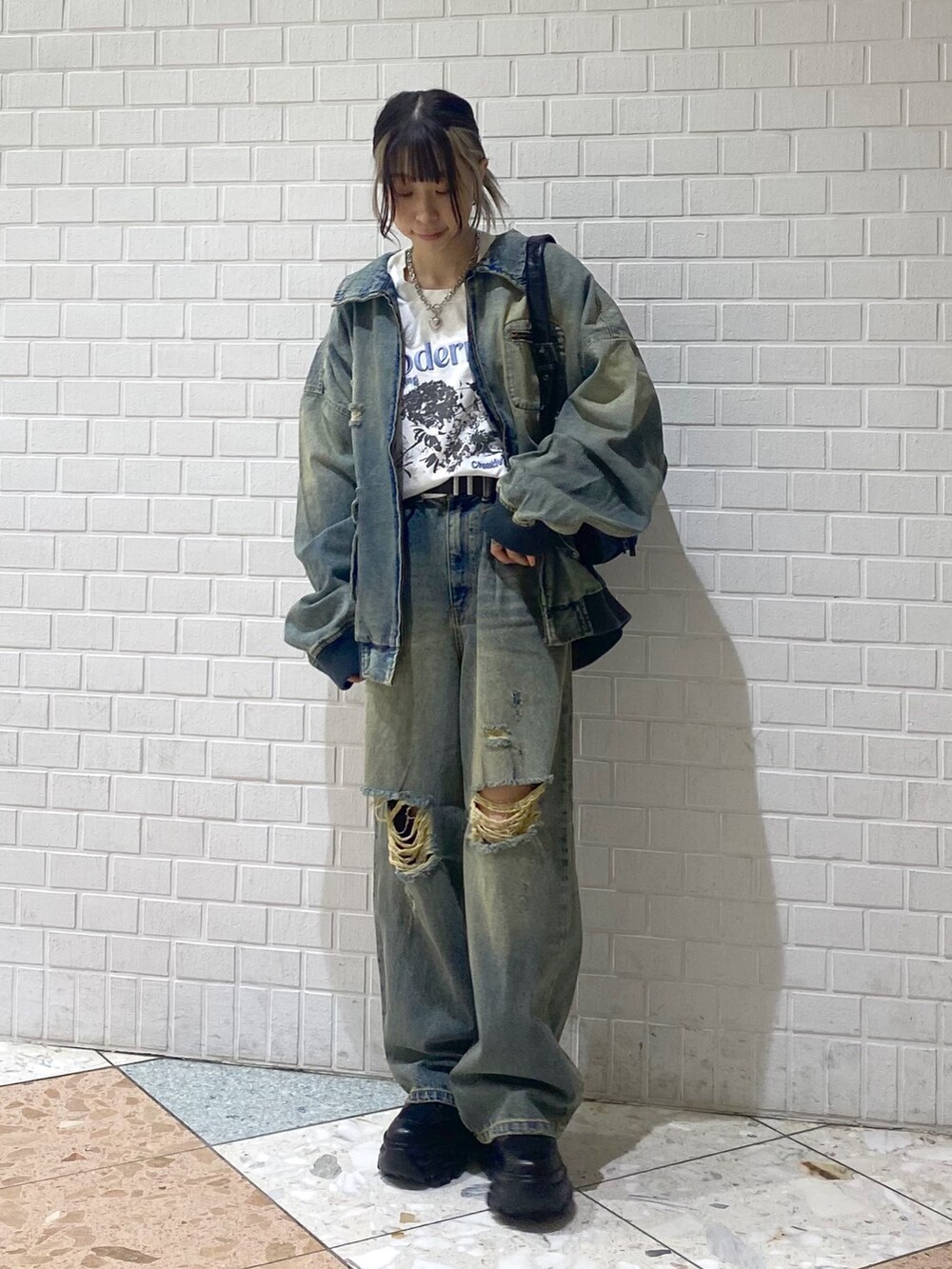 ブラック系のブーツ、ブルー系のデニムパンツ、ホワイト系のTシャツ/カットソーを着用したレディースの秋コーディネートの8枚目の写真