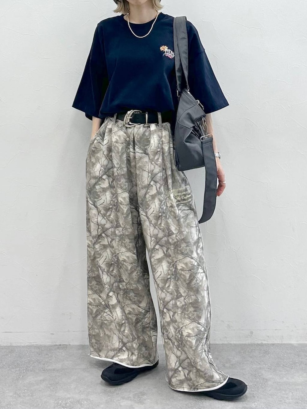 グレー系のボストンバッグ、ブラック系のスニーカー、ブルー系のTシャツ/カットソーを着用したレディースの夏コーディネートの3枚目の写真
