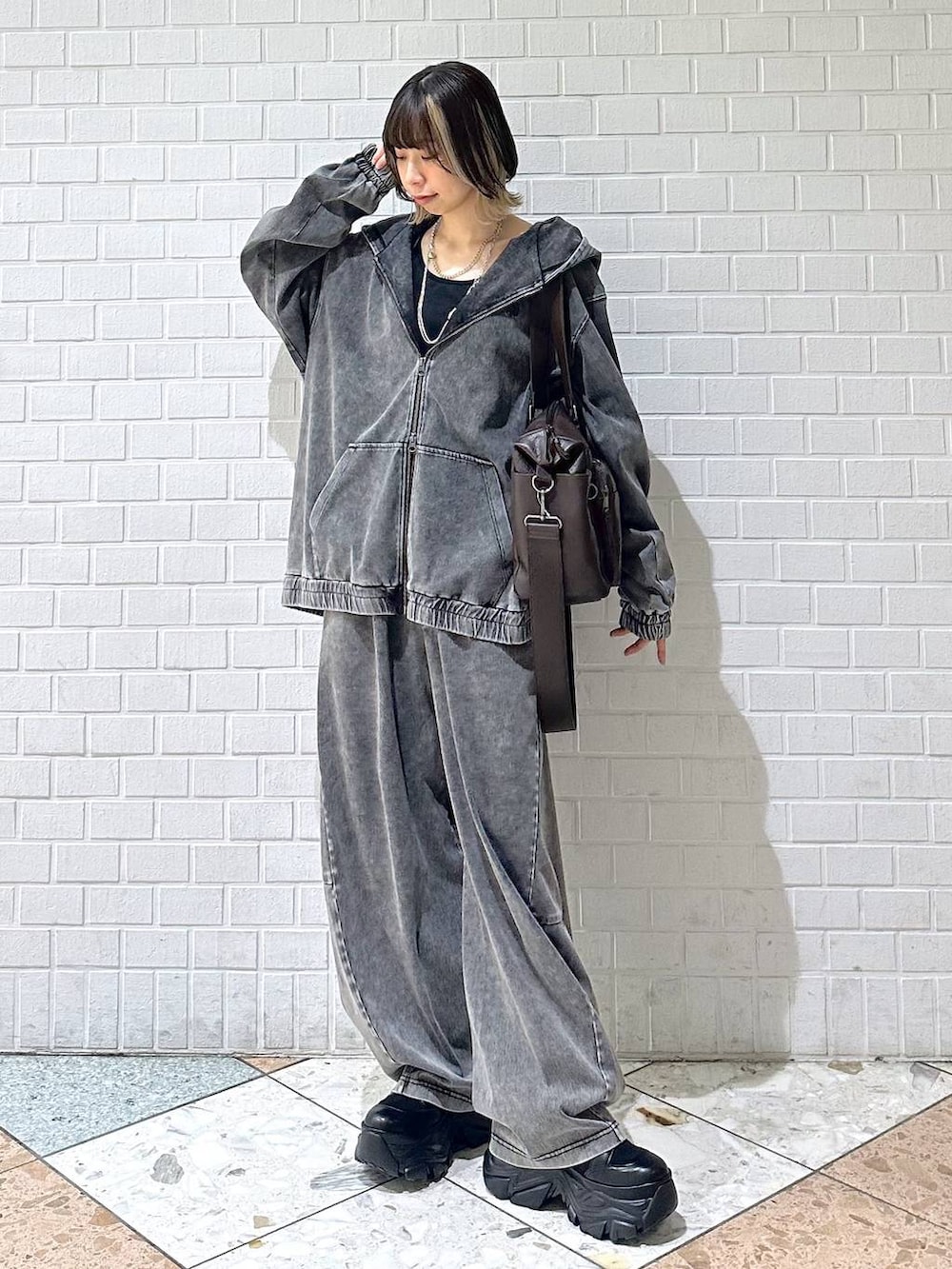 ブラック系のブーツ、ブラック系のキャミソール、ブラウン系のボストンバッグを着用したレディースの冬コーディネートの4枚目の写真