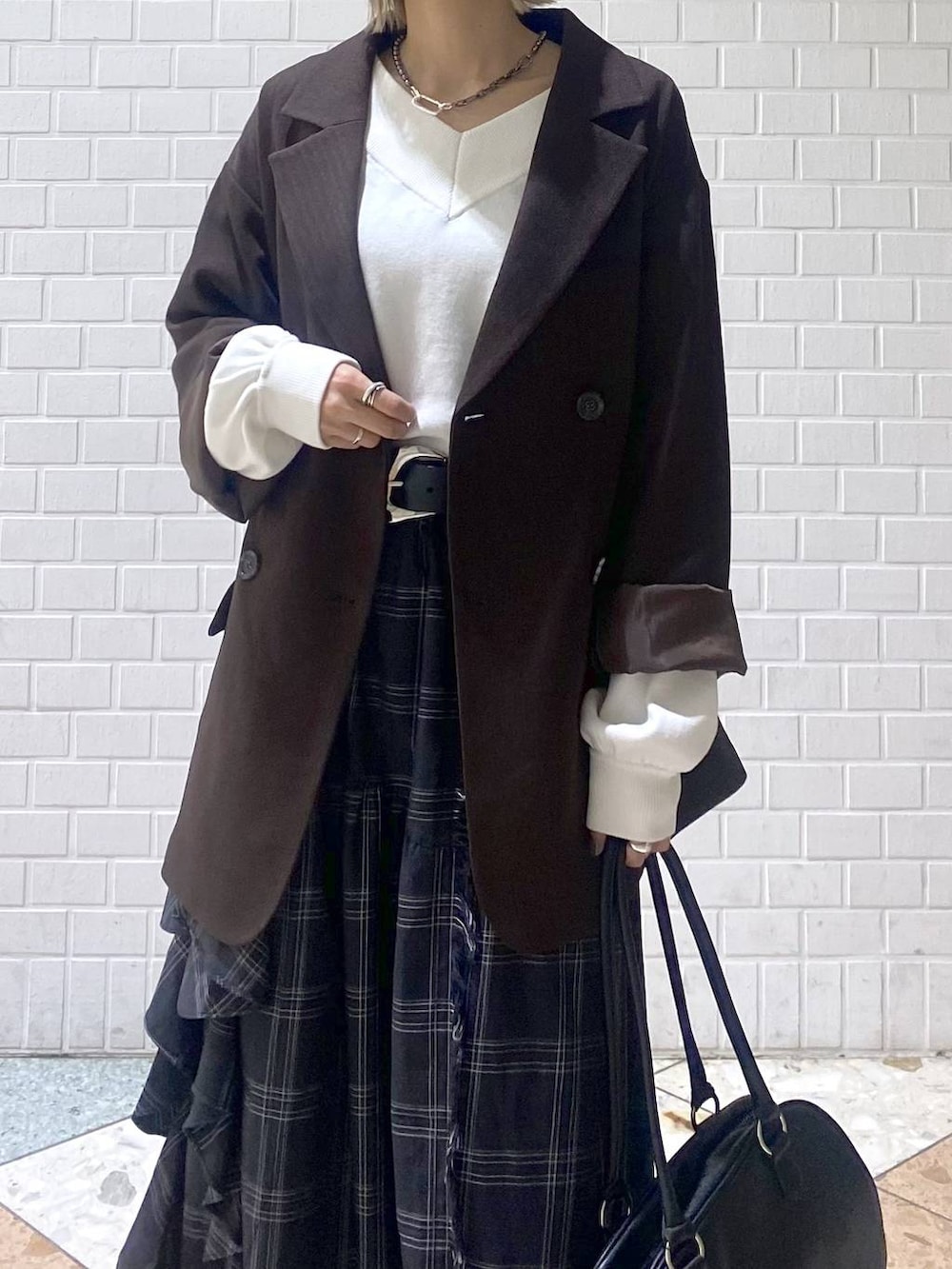 ブラウン系のブーツ、ブラック系のボストンバッグ、ホワイト系のニット/セーターを着用したレディースの秋コーディネートの8枚目の写真