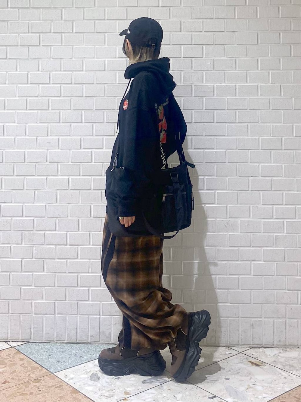 ブラウン系のブーツ、ブラック系のボストンバッグ、ブラック系のパーカーを着用したレディースの秋コーディネートの5枚目の写真