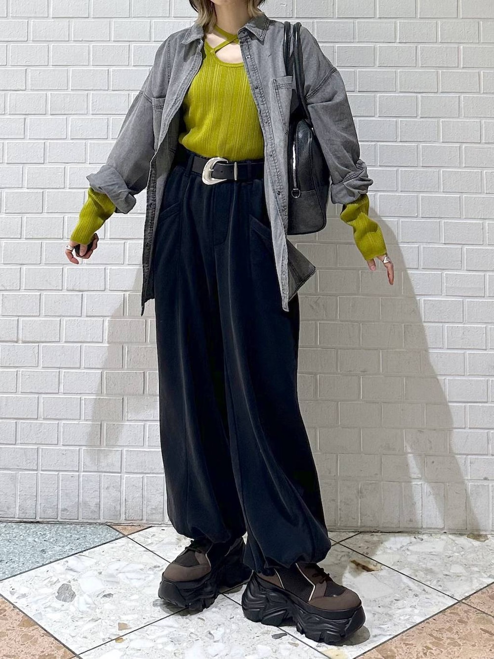 ブラウン系のブーツ、ブラック系のボストンバッグ、ブラック系のシャツ/ブラウスを着用したレディースの冬コーディネートの9枚目の写真